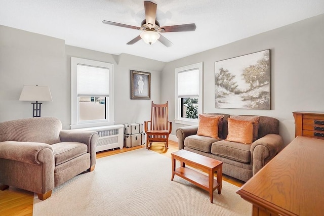 living area featuring light wood-type flooring and a ceiling fan