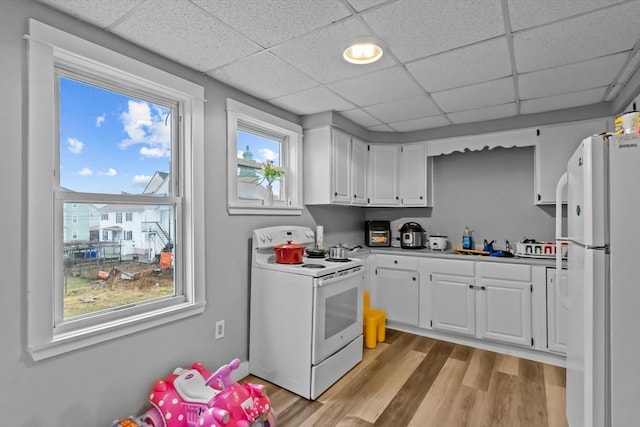 kitchen featuring a paneled ceiling, white cabinets, white appliances, and light hardwood / wood-style floors