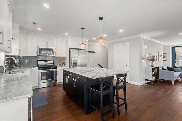51 Waltham St Unit 3, Maynard, MA 01754 - kitchen with stainless steel appliances, a sink, backsplash, white cabinetry, and ornamental molding