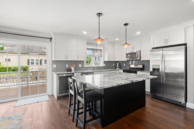 51 Waltham St Unit 3, Maynard, MA 01754 - kitchen featuring stainless steel appliances, beverage cooler, a sink, backsplash, and dark wood-type flooring