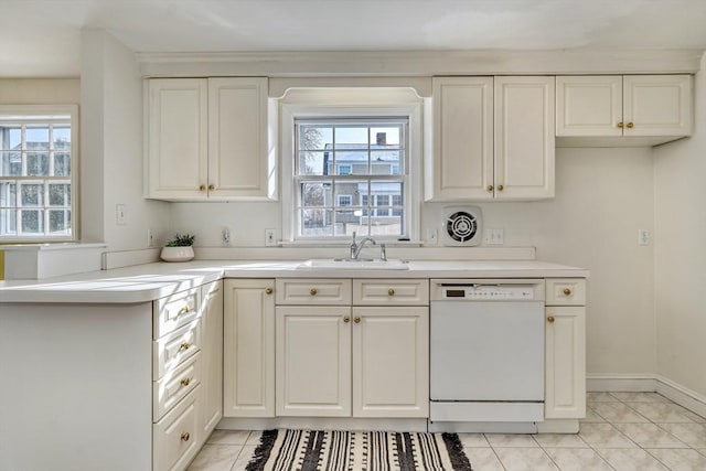 kitchen with dishwasher, light countertops, light tile patterned flooring, and a sink