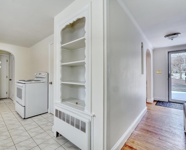 hall featuring baseboards, arched walkways, radiator heating unit, and crown molding