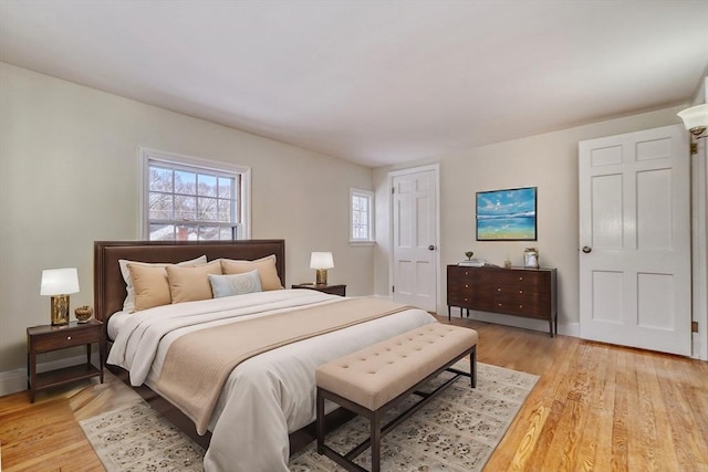 bedroom with light wood finished floors and baseboards