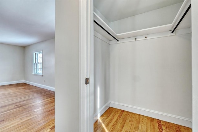 walk in closet with light wood-style floors