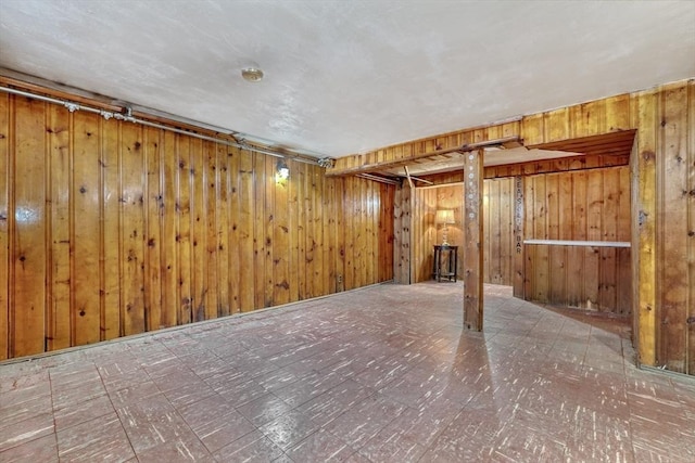 finished basement with tile patterned floors and wood walls