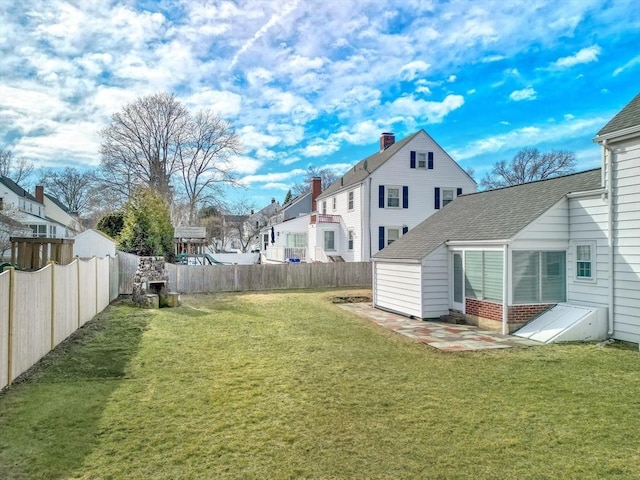 view of yard featuring a fenced backyard and a residential view