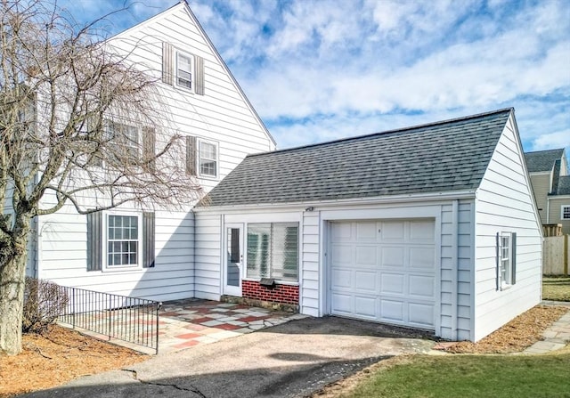 view of front of house with a garage and a shingled roof