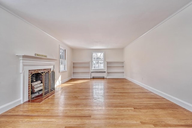 unfurnished living room featuring light wood finished floors, radiator, baseboards, a fireplace with flush hearth, and ornamental molding