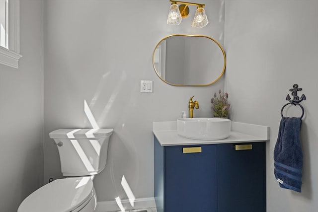 bathroom featuring baseboards, toilet, and vanity