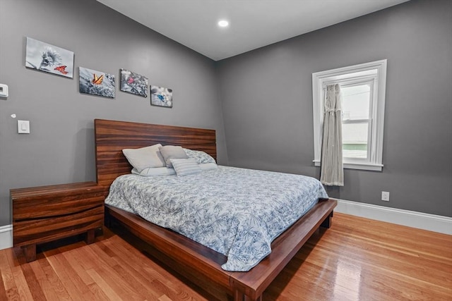 bedroom with recessed lighting, wood finished floors, and baseboards