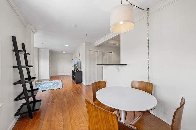 dining area featuring ornamental molding, light wood-type flooring, baseboards, and recessed lighting