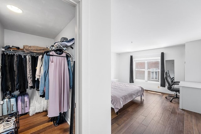 bedroom featuring wood finished floors and an office area