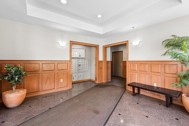 living area featuring granite floors, wainscoting, a decorative wall, and recessed lighting