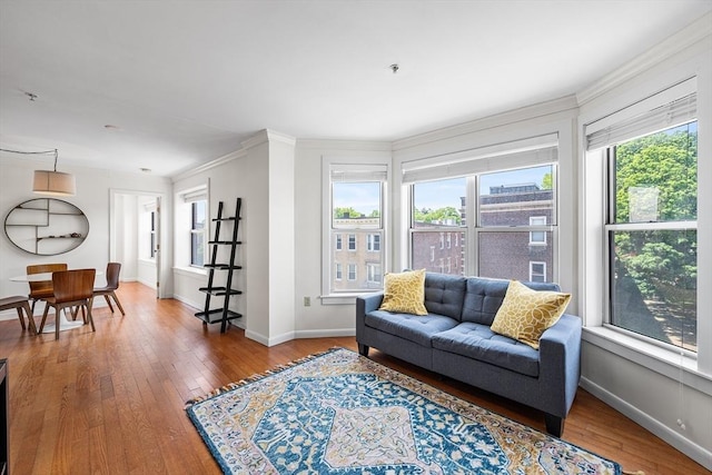 living room with plenty of natural light, ornamental molding, wood-type flooring, and baseboards