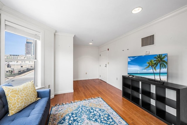 unfurnished living room featuring wood finished floors, ornamental molding, baseboards, and recessed lighting