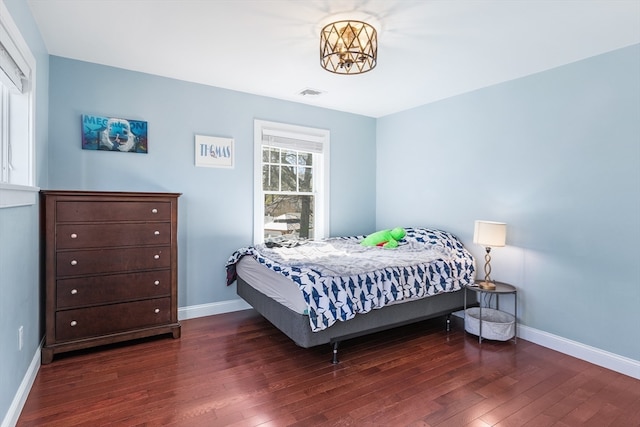 bedroom with dark hardwood / wood-style floors