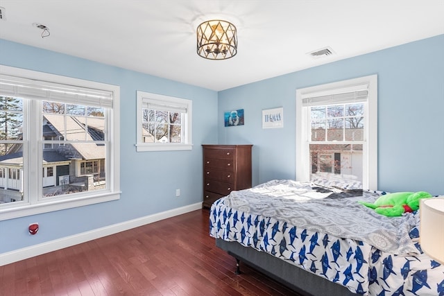 bedroom with dark wood-type flooring and multiple windows