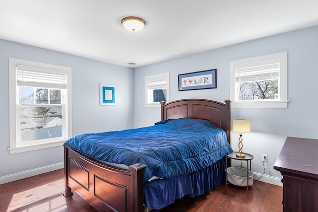 bedroom with dark wood-type flooring and multiple windows