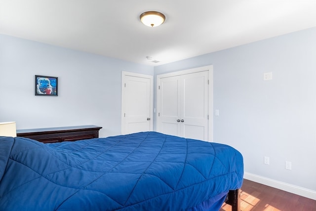 bedroom with a closet and dark hardwood / wood-style floors