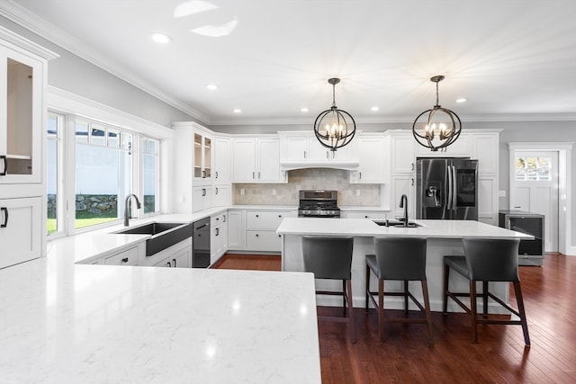 kitchen featuring backsplash, stainless steel appliances, dark wood-type flooring, pendant lighting, and a center island