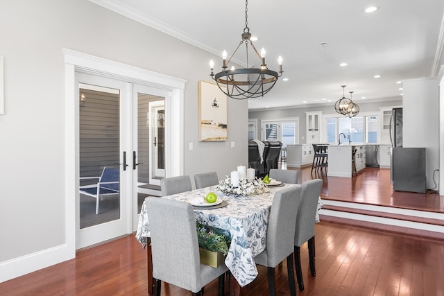 dining room featuring french doors, dark wood-type flooring, an inviting chandelier, and ornamental molding