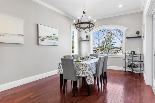 dining room with dark hardwood / wood-style flooring, a chandelier, and crown molding