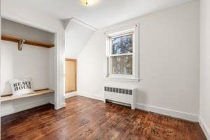 additional living space featuring radiator, dark wood-type flooring, and vaulted ceiling