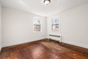 empty room featuring radiator and dark hardwood / wood-style flooring