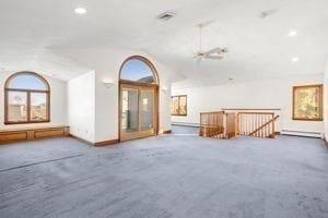 empty room with dark carpet and lofted ceiling