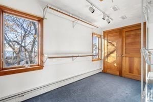 spare room with track lighting and a baseboard heating unit