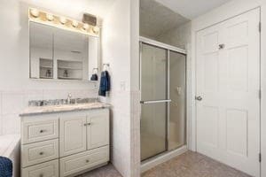 bathroom with vanity, tile walls, and walk in shower