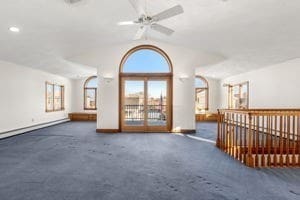 spare room with ceiling fan, dark carpet, and vaulted ceiling