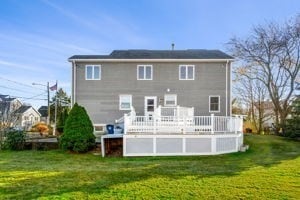 rear view of property with a lawn and a deck