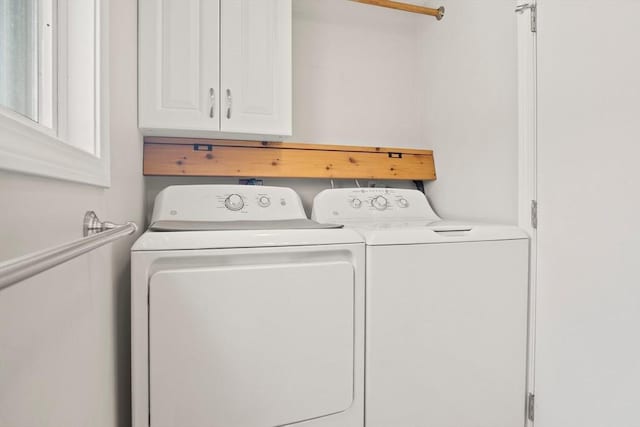 clothes washing area featuring cabinet space and separate washer and dryer