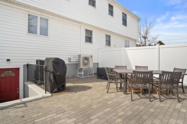 view of patio with grilling area, outdoor dining area, and fence