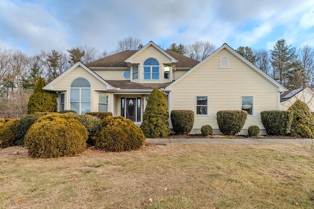 view of front of property with a front yard and roof with shingles