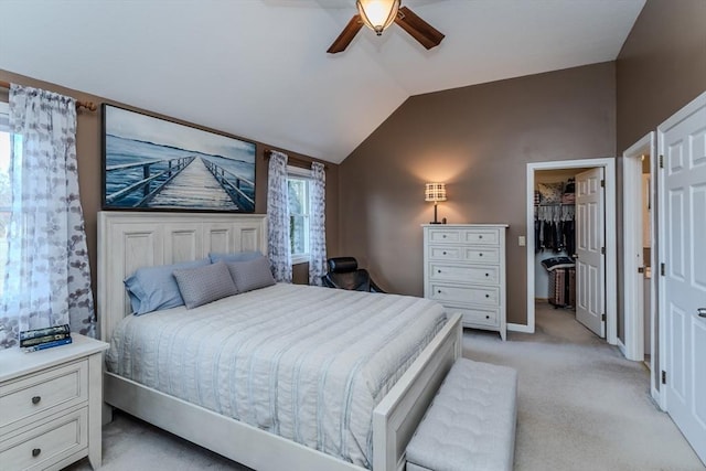 bedroom with vaulted ceiling, light colored carpet, a spacious closet, a ceiling fan, and baseboards