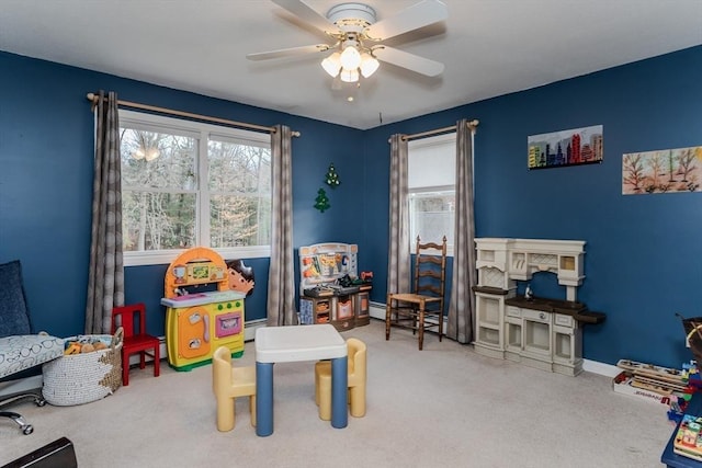 rec room featuring plenty of natural light, ceiling fan, carpet, and baseboard heating