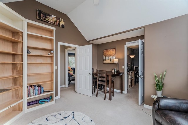 office space featuring light colored carpet, lofted ceiling, and baseboards