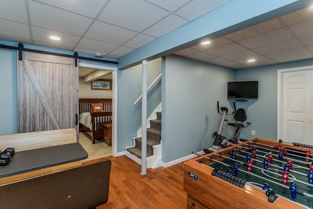 rec room with a paneled ceiling, wood finished floors, recessed lighting, and baseboards