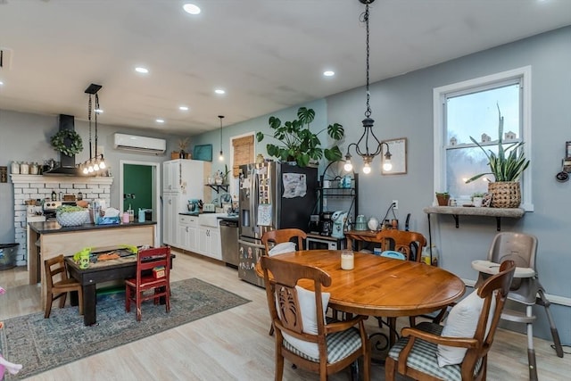 dining area with a wall mounted air conditioner, recessed lighting, and light wood-style floors