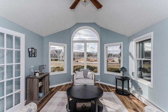 sitting room with baseboard heating, a ceiling fan, wood finished floors, and vaulted ceiling