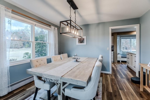 dining room featuring a baseboard heating unit, dark wood-style flooring, and baseboards