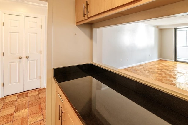 kitchen featuring light brown cabinets and baseboards