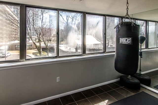 workout area with dark tile patterned floors and baseboards