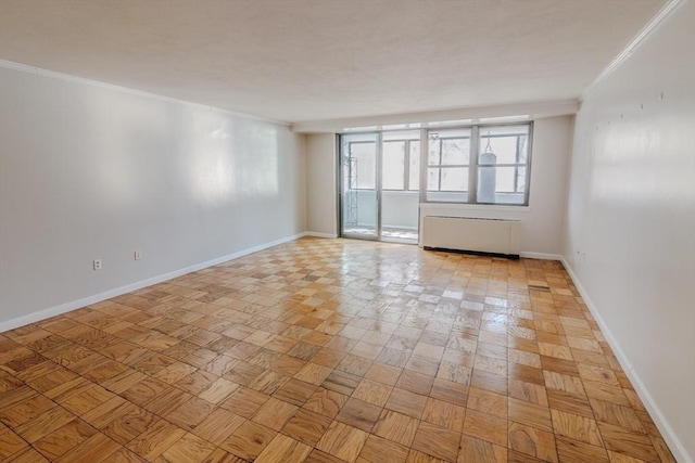 spare room featuring baseboards, radiator, and ornamental molding