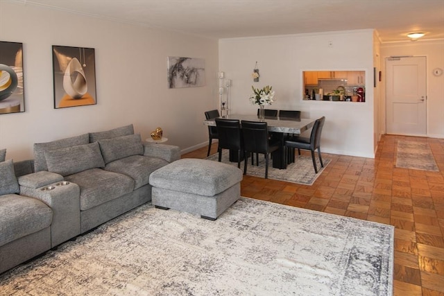 living area with baseboards and ornamental molding