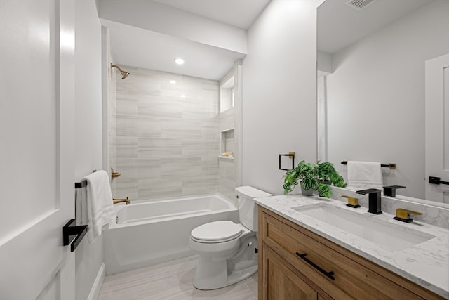 full bathroom featuring tiled shower / bath combo, vanity, and toilet