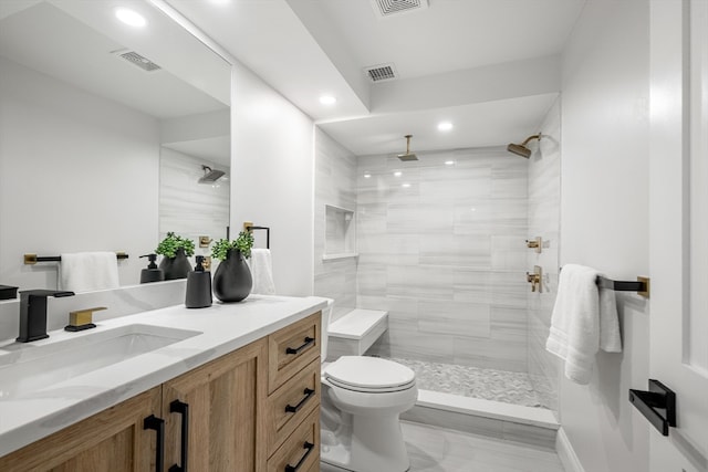 bathroom featuring vanity, toilet, and tiled shower