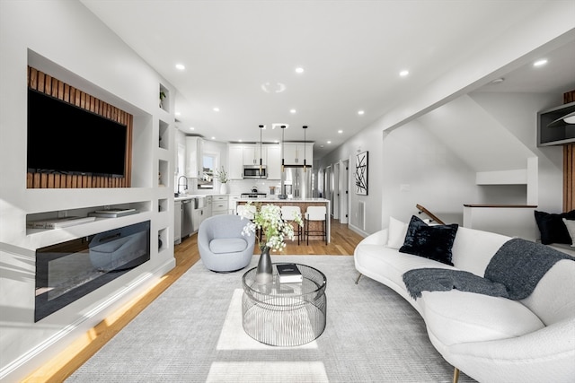 living room featuring light wood-type flooring and sink